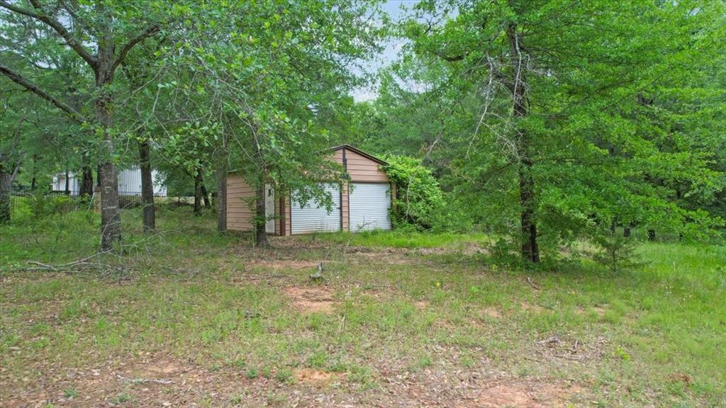 380 Timber Lakes Drive Powderly, TX 75473 - Photo 10 of 19 a backyard of a house with lots of green space