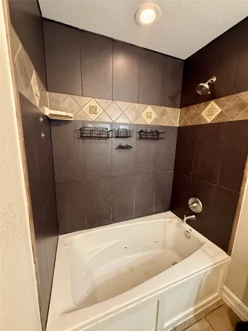 a bathroom with a granite countertop sink and tub