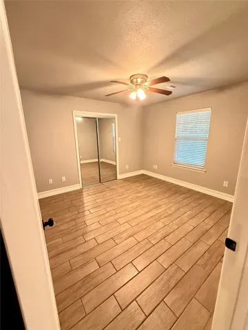 a view of empty room with wooden floor