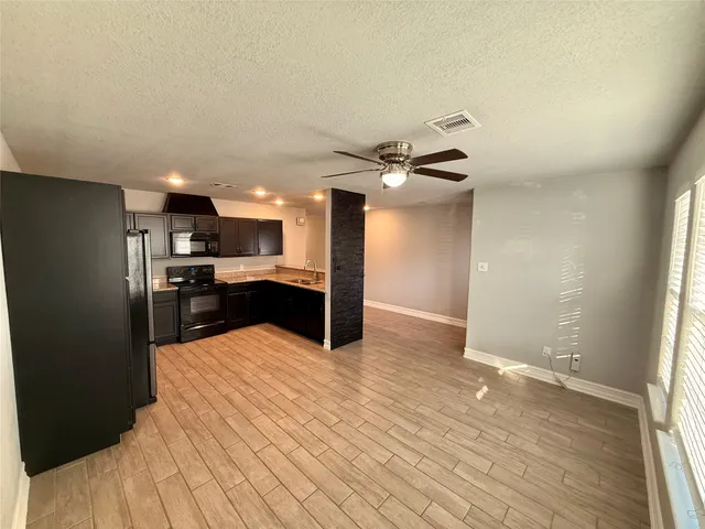 a kitchen with stainless steel appliances kitchen island granite countertop a refrigerator and a sink