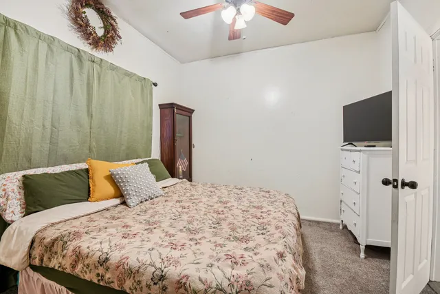a bedroom with a bed tv and a chandelier