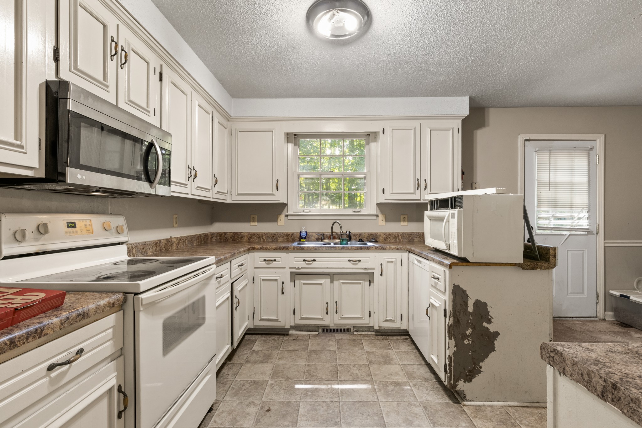 206 Pine Mountain Road Clarksville, TN 37042 - Photo 5 of 17 a kitchen with stainless steel appliances granite countertop a stove a sink and a microwave