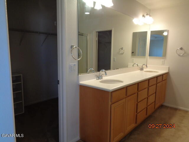 43660 Windrose Place Lancaster, CA 93536 - Photo 12 of 26 a bathroom with a double vanity sink and mirror