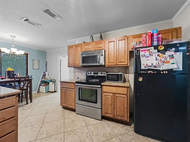 a kitchen with stainless steel appliances granite countertop a refrigerator and a stove top oven