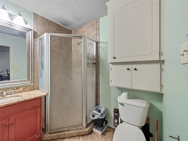 a bathroom with a granite countertop sink toilet and shower