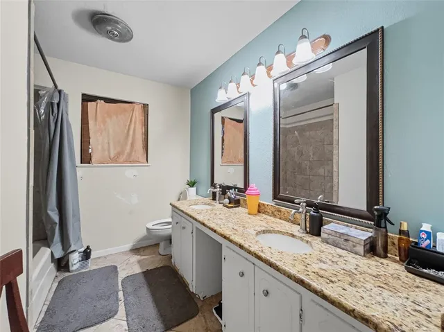 a bathroom with a granite countertop sink a mirror and a bathtub