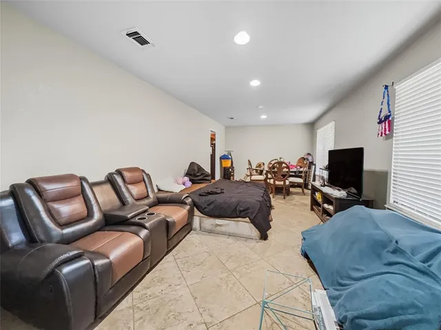a living room with furniture kitchen view and a flat screen tv