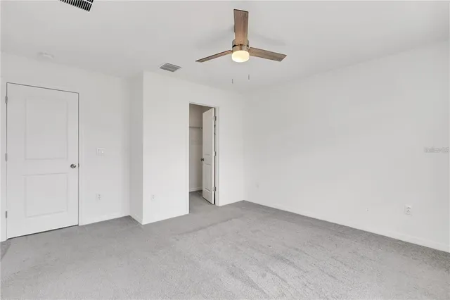 an empty room with a window and a ceiling fan