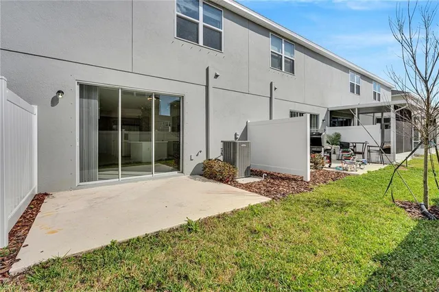 a view of a white house with large windows and a small yard
