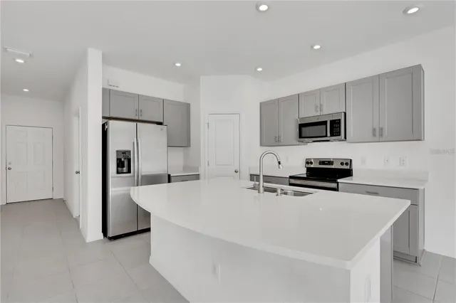 a kitchen with stainless steel appliances a refrigerator sink microwave and cabinets