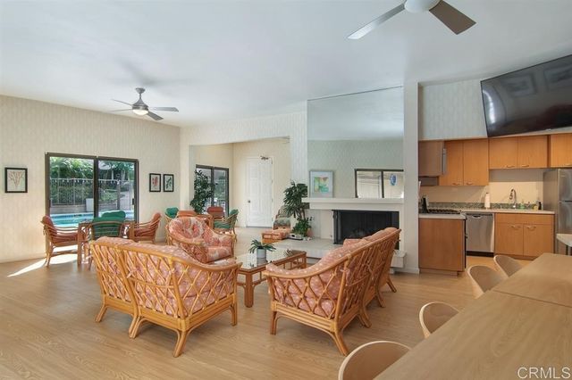 a living room with furniture kitchen view and a large window