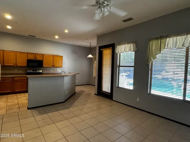 a kitchen with stainless steel appliances a large counter top a stove a chimney a sink and a large window