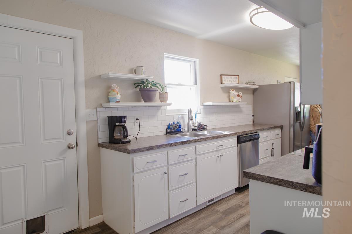 1404 Rochester Street Caldwell, ID 83605 - Photo 19 of 29 Kitchen featuring white cabinetry, dark speckled countertops, subway tile backsplash, and a stainless steel dishwasher