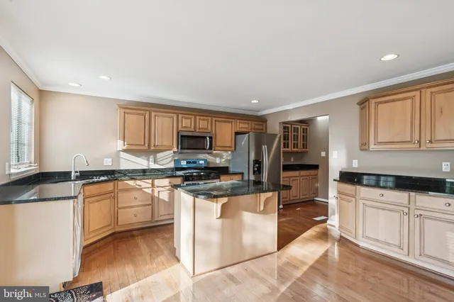 a kitchen with stainless steel appliances granite countertop a refrigerator sink and stove