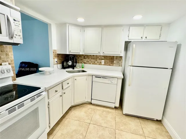 a kitchen with cabinets appliances and a sink