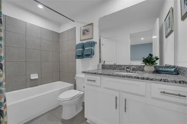 a bathroom with a granite countertop sink a toilet and a mirror