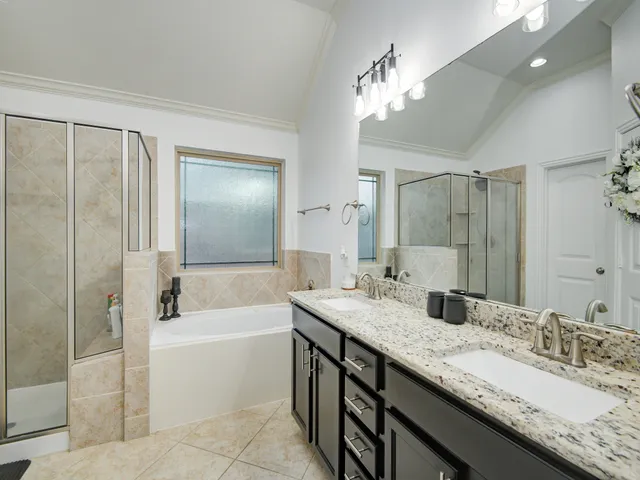 a bathroom with a tub a mirror and a shower