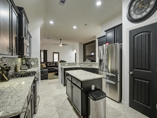 a kitchen with stainless steel appliances granite countertop sink stove top oven and microwave