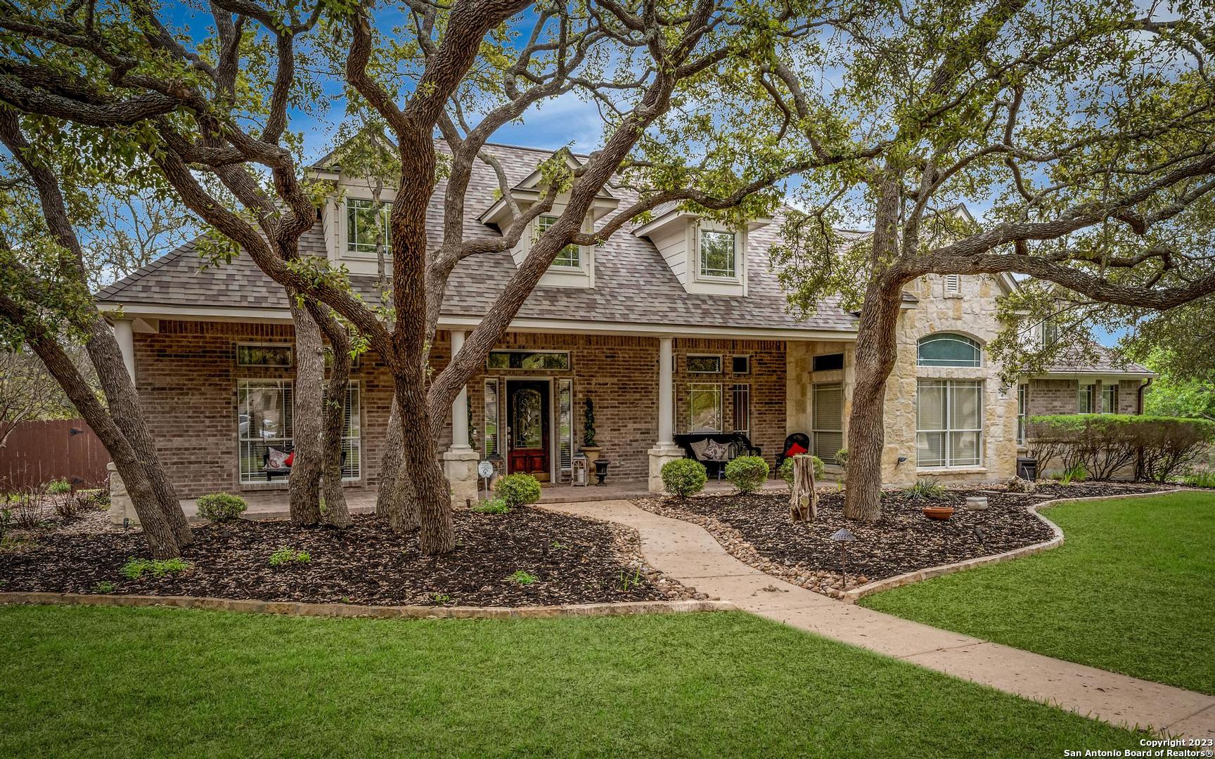 28402 Woodbridge Fair Oaks Ranch, TX 78015 - Photo 1 of 1 a front view of a house with a garden and trees