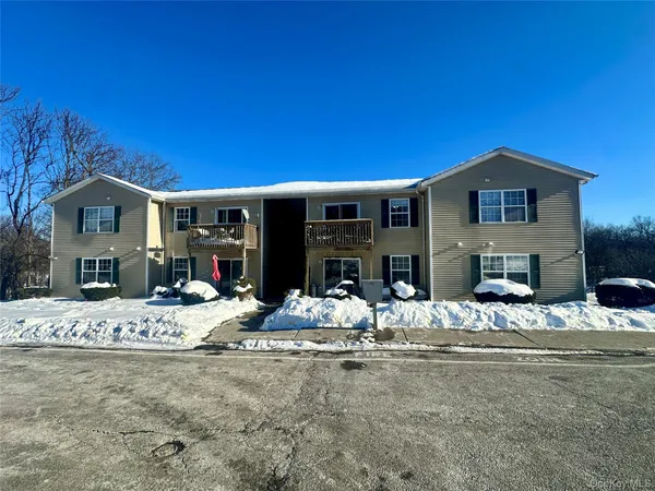 a view of a house with snow on the side of the road