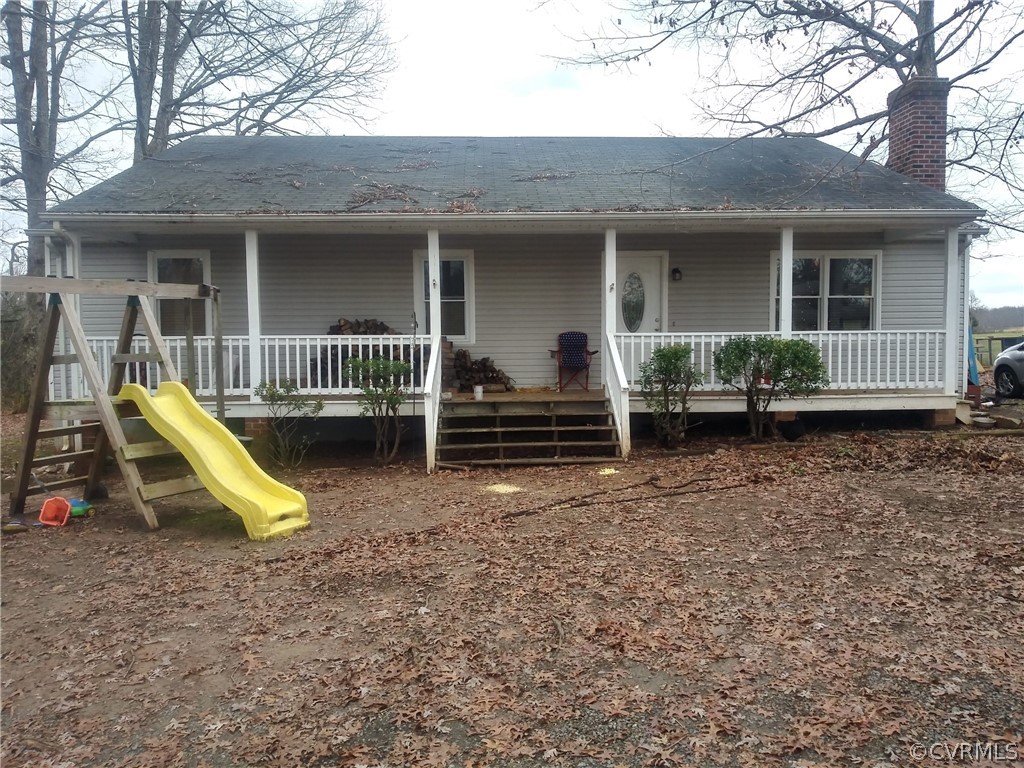 a view of a house with a yard porch and wooden fence
