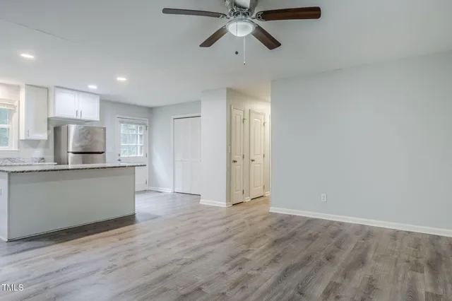 a view of a room with wooden floor and a ceiling fan