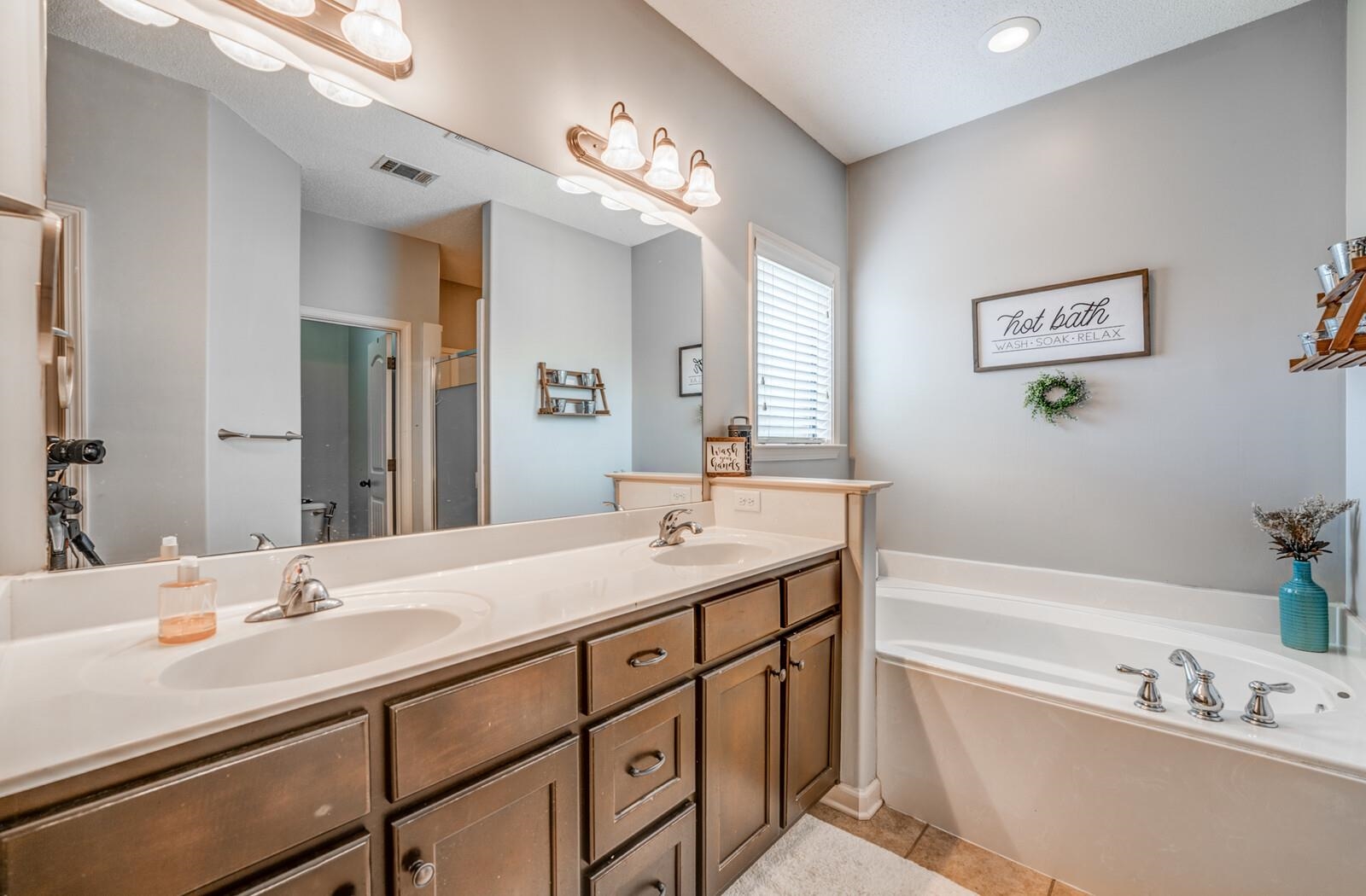 4671 Hampton Ridge Lane Bartlett, TN 38002 - Photo 25 of 40 Bathroom featuring a dual-sink vanity with a light-colored countertop and dark wood-finish cabinetry
