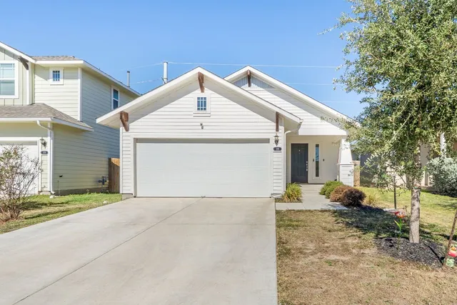 a view of a house with a yard and garage
