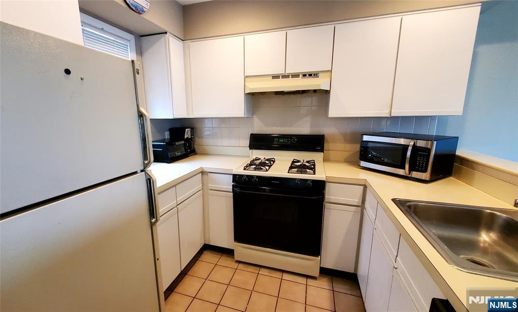 1159 Radio Road, Unit 7 Little Egg Harbor, NJ 08087 - Photo 7 of 38 a kitchen with a sink a stove and cabinets