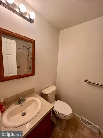 a bathroom with a toilet a sink and mirror