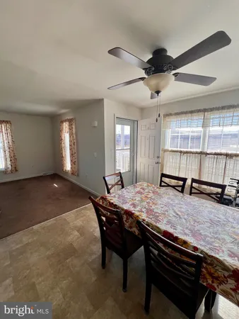 a dining hall with stainless steel appliances granite countertop a stove a sink a dining table and chairs with wooden floor