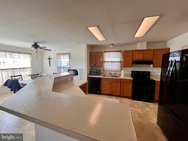 a large kitchen with a large counter top stainless steel appliances and cabinets