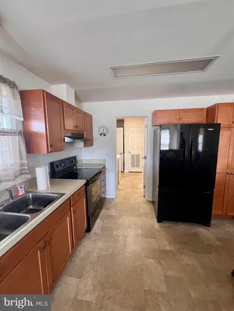 a large kitchen with stainless steel appliances granite countertop a refrigerator a sink and dishwasher