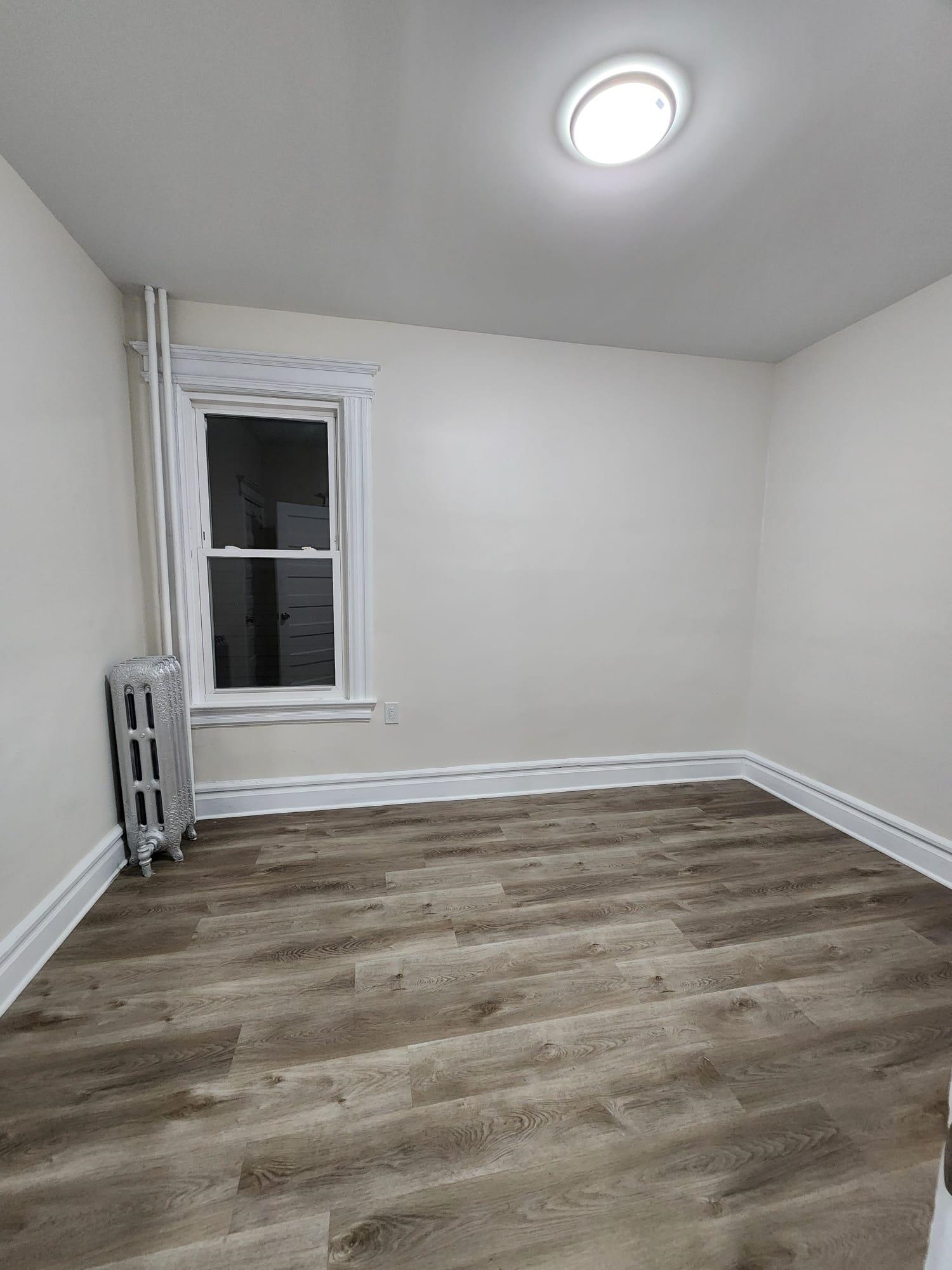 65 Halstead Street, Unit 2 Kearny, NJ 07032 - Photo 11 of 16 a view of an empty room with wooden floor and a window
