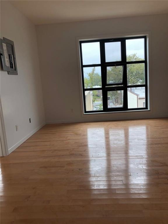128 Bay 43rd Street, Unit 3D Brooklyn, NY 11214 - Photo 3 of 6 a view of an empty room with wooden floor and a window