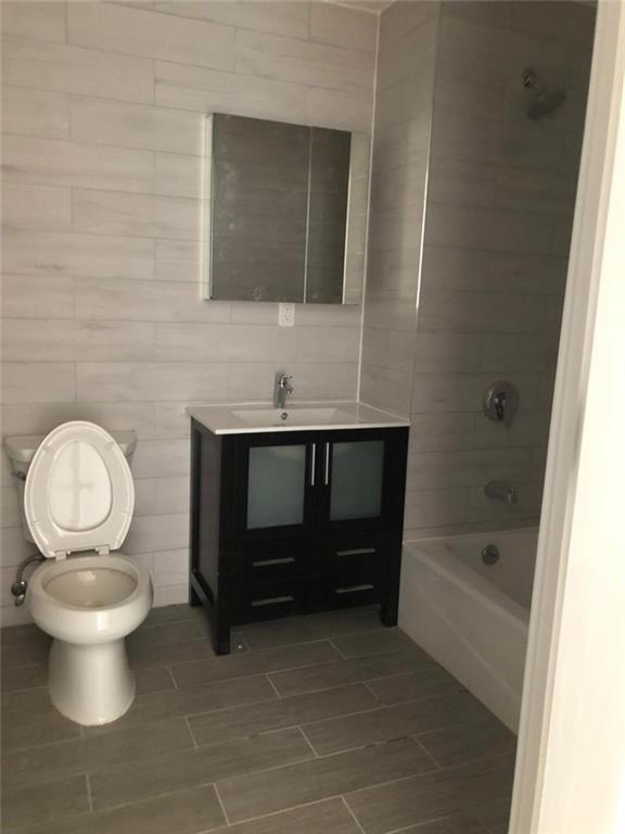 128 Bay 43rd Street, Unit 3D Brooklyn, NY 11214 - Photo 4 of 6 a bathroom with a toilet sink and mirror