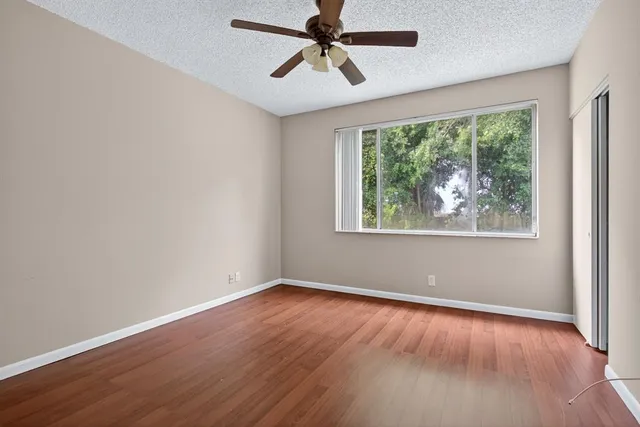 a view of room with window ceiling fan and hardwood floor