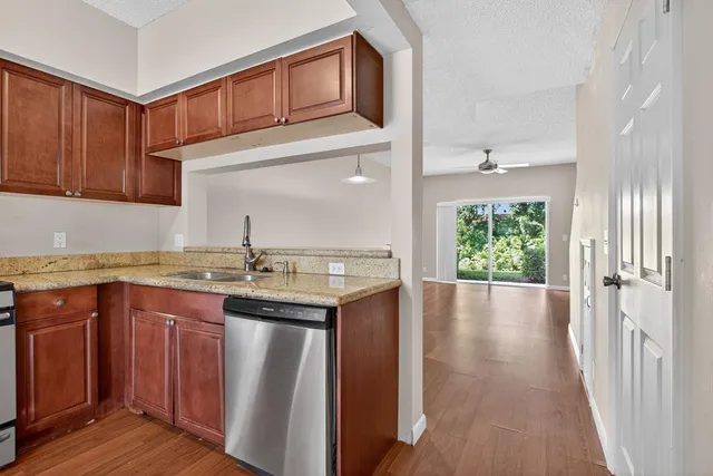 a kitchen with stainless steel appliances granite countertop a sink and wooden cabinets