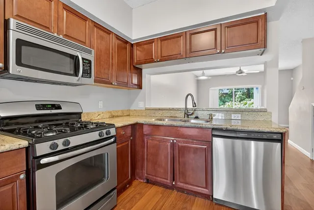 a kitchen with stainless steel appliances granite countertop a stove microwave and sink