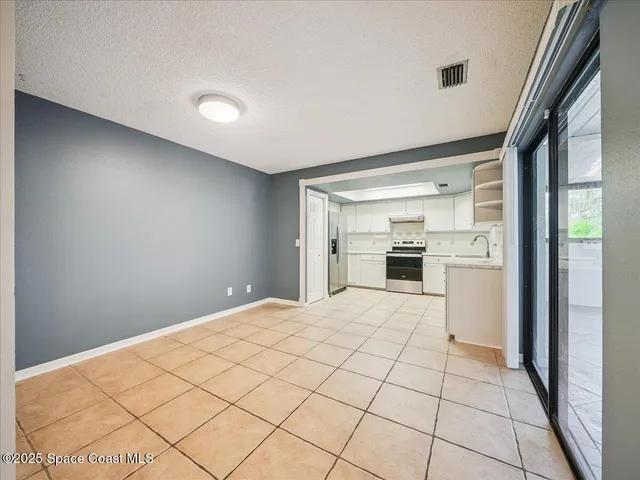 a view of a kitchen with a sink and refrigerator