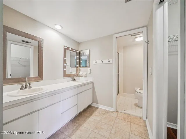 a spacious bathroom with a shower sink and mirror