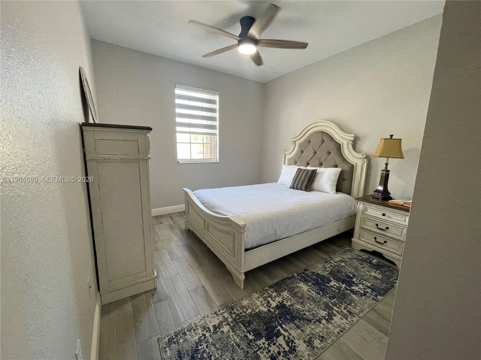 8900 Southwest 226th Terrace Cutler Bay, FL 33190 - Photo 14 of 40 a bedroom with a bed and a chandelier
