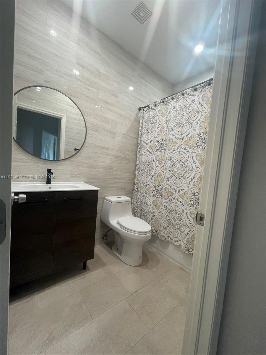 8900 Southwest 226th Terrace Cutler Bay, FL 33190 - Photo 20 of 40 a bathroom with a toilet a sink and mirror