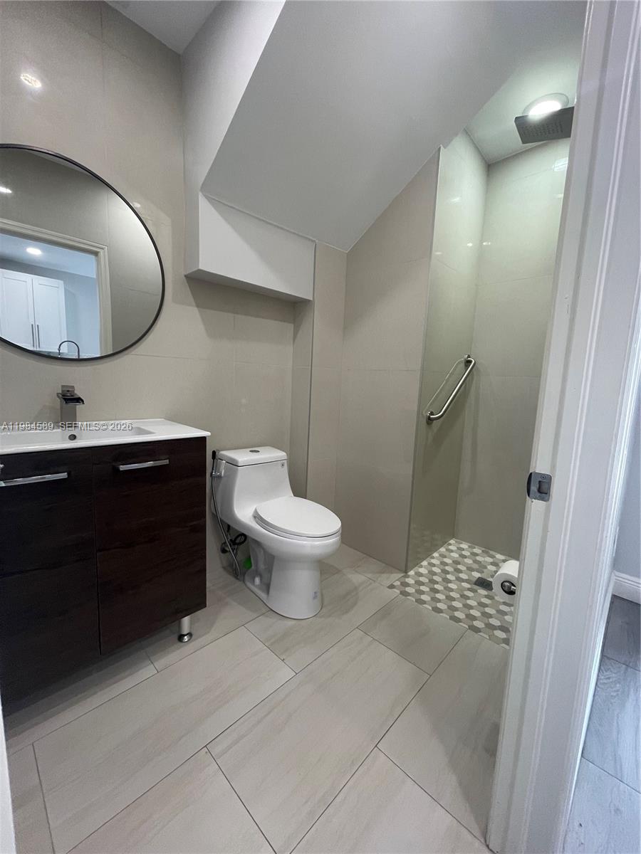 8900 Southwest 226th Terrace Cutler Bay, FL 33190 - Photo 3 of 40 a spacious bathroom with a toilet a sink and mirror