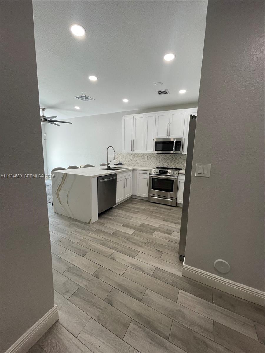 8900 Southwest 226th Terrace Cutler Bay, FL 33190 - Photo 33 of 40 a large white kitchen with a stove a sink dishwasher and a refrigerator