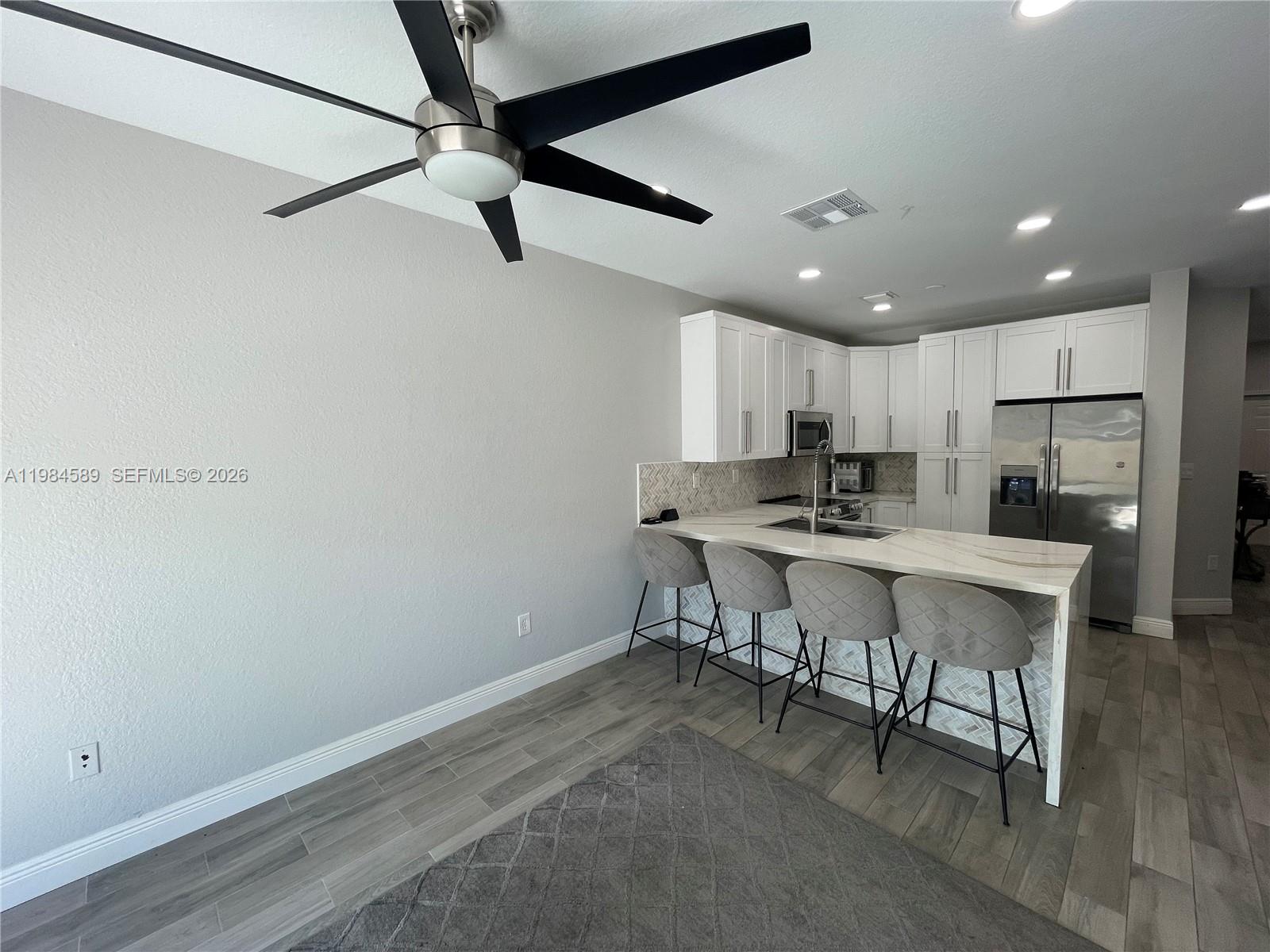 8900 Southwest 226th Terrace Cutler Bay, FL 33190 - Photo 35 of 40 a kitchen with a table chairs refrigerator and cabinets