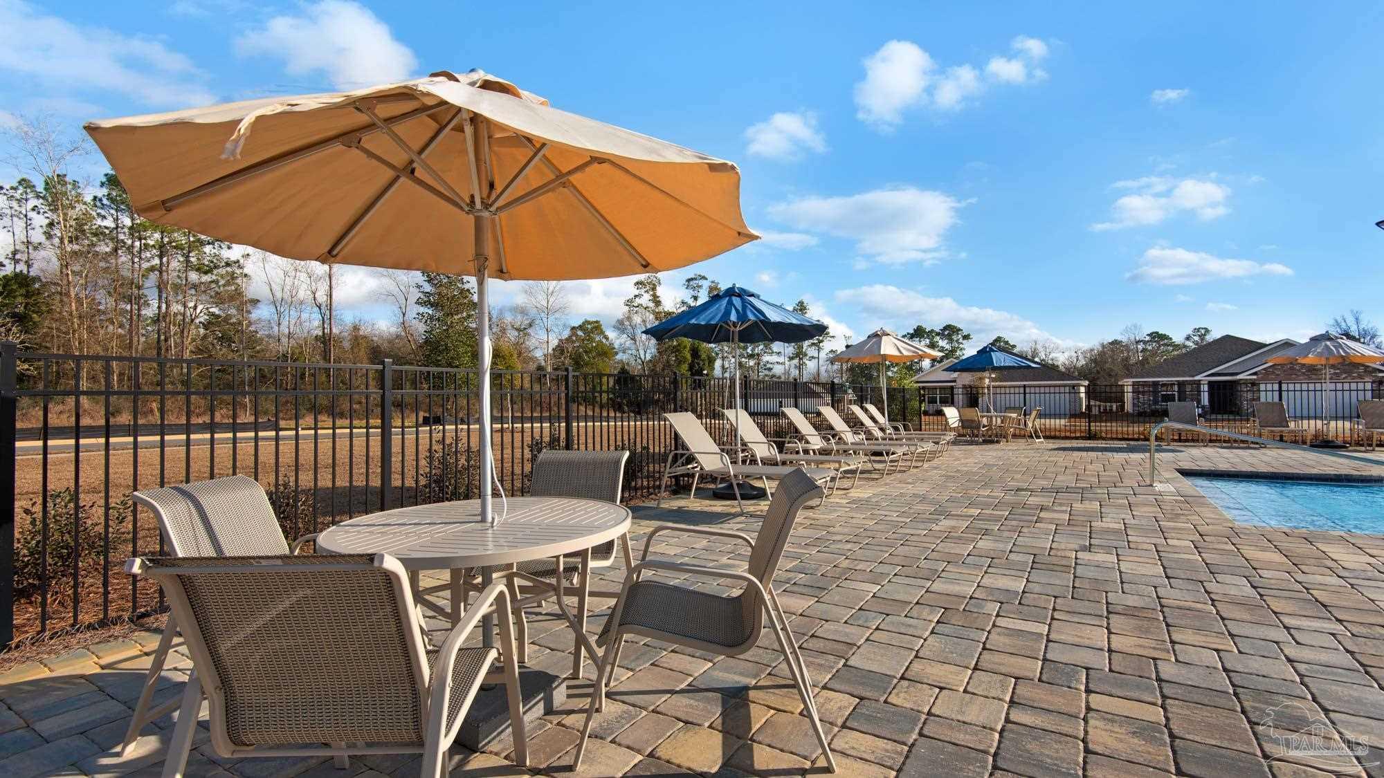 136 Albatross Street Cantonment, FL 32533 - Photo 41 of 43 a view of a patio with a table and chairs under an umbrella
