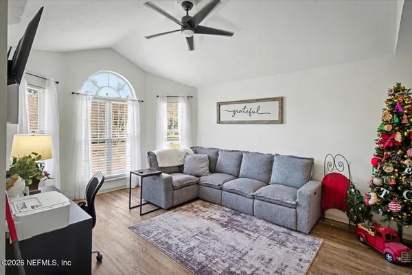 a living room with furniture potted plant and a large window