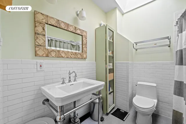 a bathroom with a sink toilet and a mirror