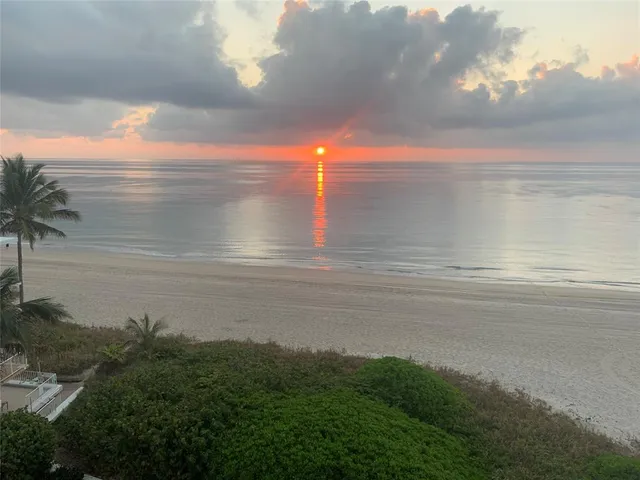 a view of a room with a floor to ceiling window and chair